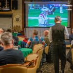 Fans watching an American football broadcast on television at home