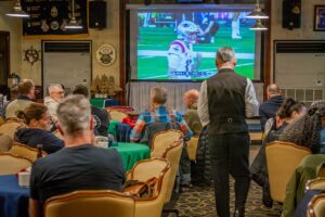 Fans watching an American football broadcast on television at home