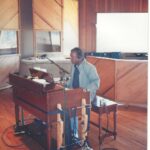 A musician performing at an organ inside a professional recording studio.