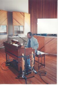 A musician performing at an organ inside a professional recording studio.